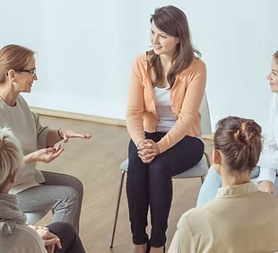 A group of people sitting in a circle having a discussion.