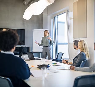 A woman teaches a workshop in an office setting.