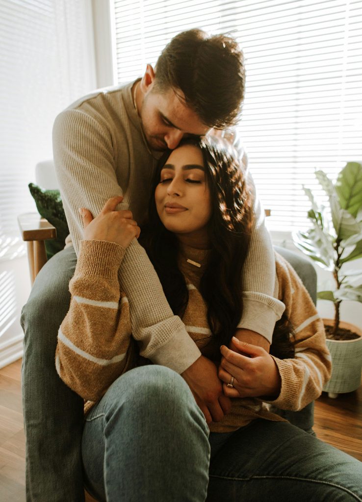 Maternal mental health and fertility challenges - a couple sitting at home holding each other.